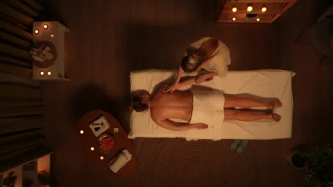 Top view of spa salon room, female laying on massage table covered by towel Stock Footage 252394044