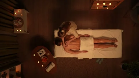 Top view of spa salon room, woman laying on massage table, female therapist Vídeo Stock 252394375