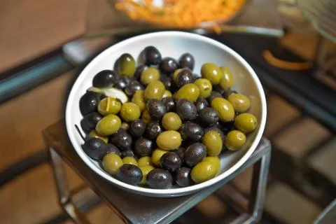 Top view with space for text . Green and black olives in a white ceramic bowl Stock Photos