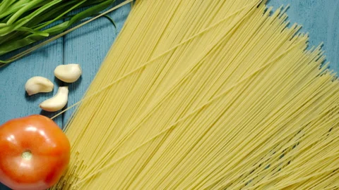 TOP VIEW: Spaghetti Falling Down On The Blue Wooden Table Vídeos de archivo 163582150