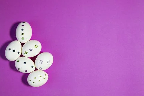 Top View of Sparkling White Easter Eggs on Purple Foto stock