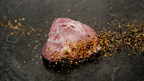 TOP VIEW: Spices fall on raw pork steak. Slow motion. Vídeos de archivo 144416316