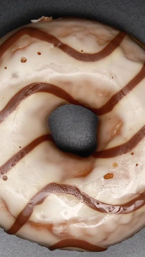 Top View Spinning Donut Glazed With White Icing With Brown Curls On A Black Plat Vídeos de archivo 268165408