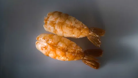Top view of spinning two nigiri shrimp sushi. Video stock 127106380