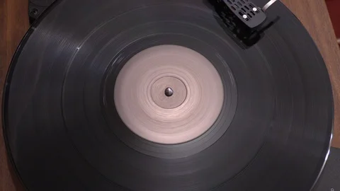 Top view of spinning vinyl disc turntable being stopped Stock Footage 120537697