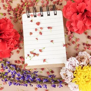 Top View of Spiral Notebook Framed by Hibiscus and Roses. Stock Photos