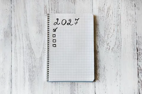 Top view of a spiral notebook marked 2027 with a handwritten checklist Фото