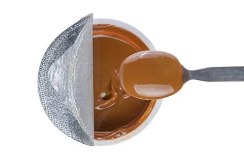 Top view of spoon scooping dulce de leche out of a pot, traditional sweet f.. Stock Photos