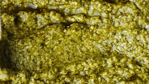 Top view of a spoon stirring green basil pesto sauce Stock Footage 340549904