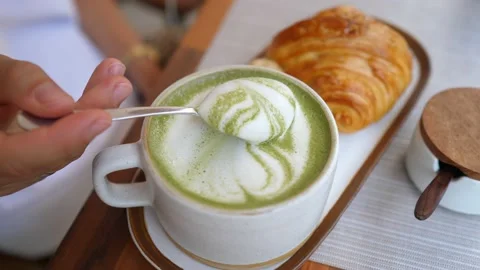 Top view of spoon taking froth off the matcha latte. Healthy dairy free drink Stock Footage 147859513