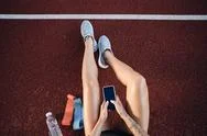 Top View Of Sporty Girl With Cellphone Resting After Workout On City Stadium Stock Photos