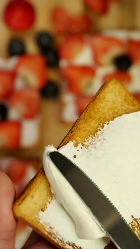 Top view spread white cream cheese onto a toasted slice of bread using a knife a 스톡 동영상 261957452