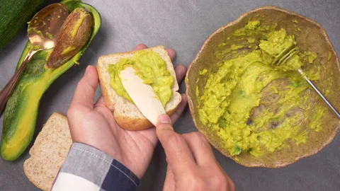 Top view of Spreading Mashed Avocado On Toast. Healthy Vegan Breakfast Stock Footage 135776776