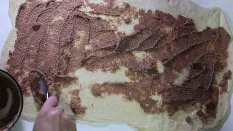 Top view of spreading sweet chocolate filling on the risen dough. Stock Footage 298334586