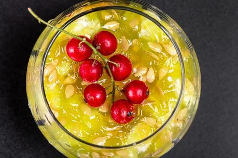 Top view, a sprig of red currant on the pulp of a Kiwano fruit with seeds i.. Fotos de archivo
