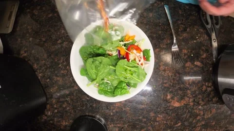 Top view of sprinkling red chilli flakes on fresh homemade salad. Video stock 321497946