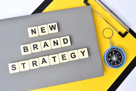 Top view of square letters with text NEW BRAND STRATEGY. Stock Photos