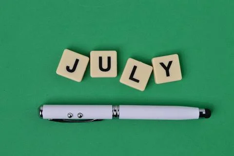 Top view of square letters with text JULY. Stock Photos