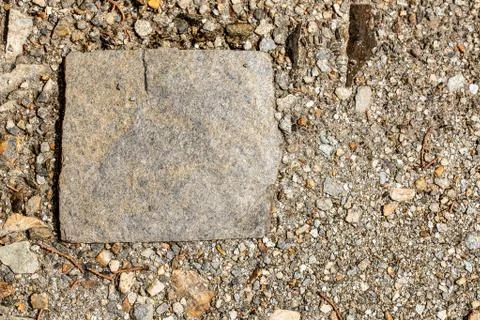 Top view of a square shaped stone on a shingle beach with copy space 스톡 사진