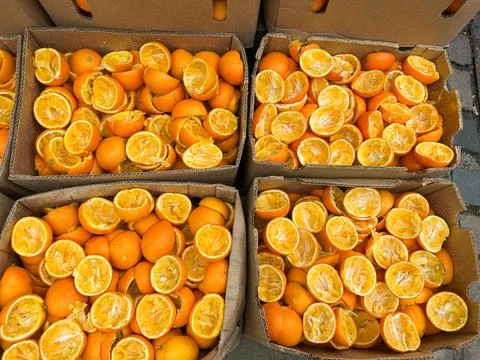 Top view of squeezed orange halves piled up inside cardboard boxes after ma.. Stock Photos