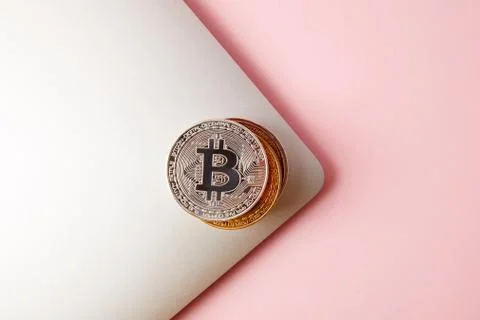 Top view of stack of bitcoins on laptop on pink Foto stock
