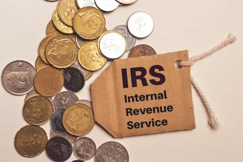 Top view stack of coins and label tag written with IRS stands for Internal Re Stock Photos