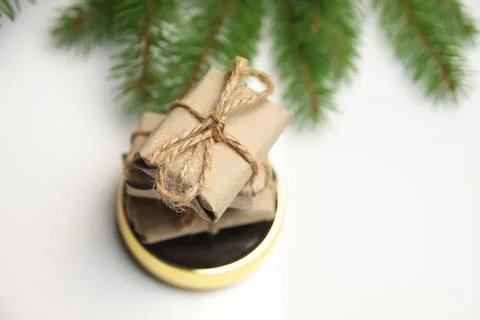 Top view stack of craft little gifts standing on round gold mirror on white b Foto stock