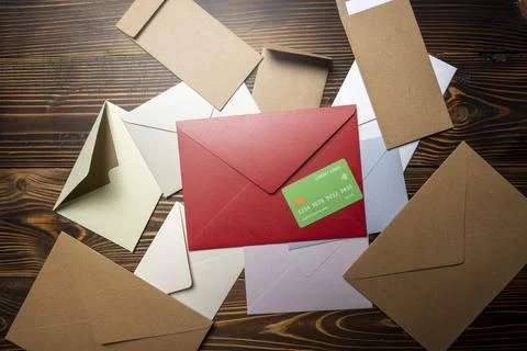 Top view of stack of envelope and postcard with credit card on wooden backg.. Stockfoto's