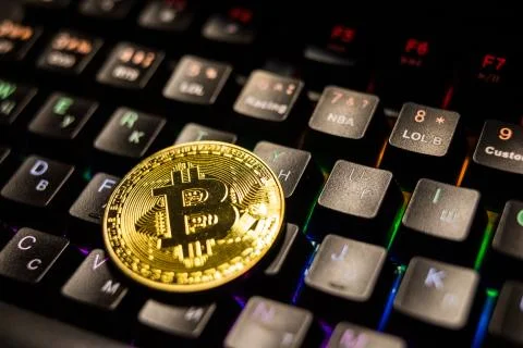 Top view stack of golden Bitcoins money on computer light keyboard. Cryptocur Stock Photos