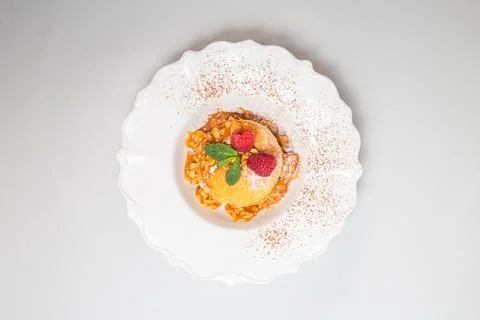 Top view of a stack of pancakes with raspberries and mint on white plate Stock Photos