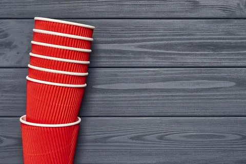 Top view of a stack of red paper cups on wooden plank surface Stock Photos
