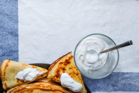 Top view on a stack of rosy freshly baked pancakes on a brown plate. Stock Photos