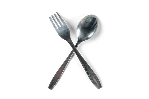 Top view stacked fork and spoon in cross shape isolated white background Stock Photos