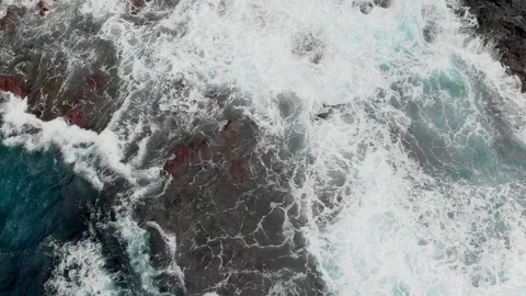 Top view. Steep volcanic shore, reefs of frozen volcanic lava, stormy ocean Video stock 104233174
