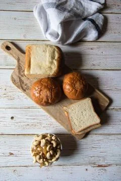 Top view of still life with bread, dry fruits and buns on a wooden platter Stock Photos