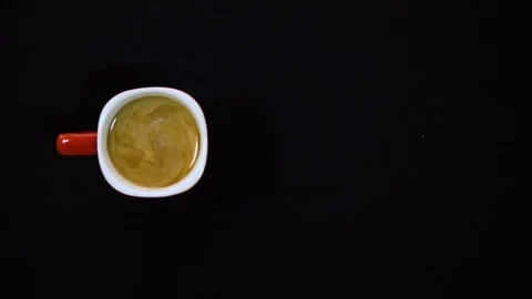 Top view of stirring coffee with spoon. slow motion of pouring milk into coffee  Stock Footage 128768749