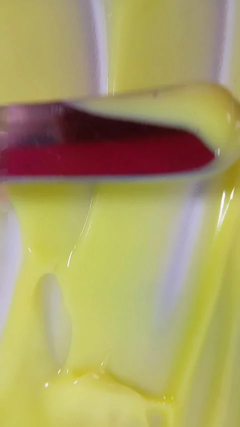 Top view of stirring yellow liquid using a metal tool. Liquid being evenly .. Vídeo Stock 346933072