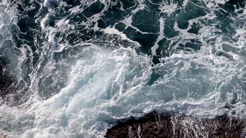 Top view of the stormy sea. The waves foam and break on the rocks. Stock Footage 127057657