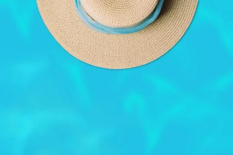 Top view of straw beach hat with blue string on water background. Stock Photos