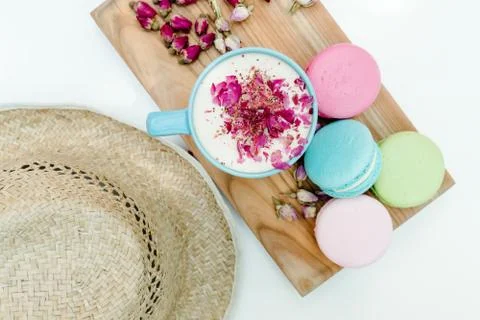 Top view on straw hat and blue cup of aroma cappuccino with french tasty maca 스톡 사진