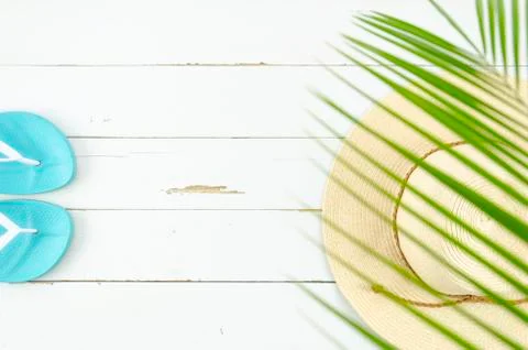 Top view straw hat, and beach slippers on white. Flat lay summer vacation Stock Photos