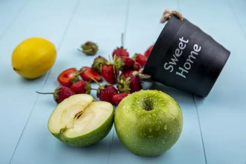 Top view of strawberry falling out of a basket with green apples with lemon.. Stock Photos