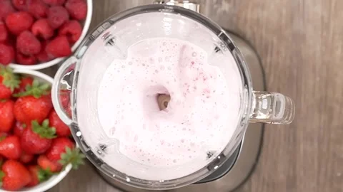 Top view of a strawberry raspberry smoothie blending in a blender, slow mot.. Stock Footage 317994985