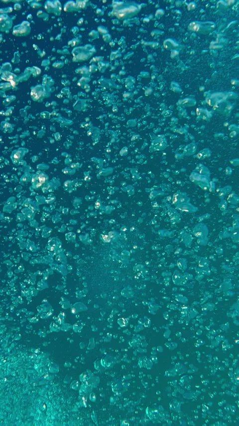 Top view: stream of air bubbles flowing upwards in blue ocean Stock Footage 325390113