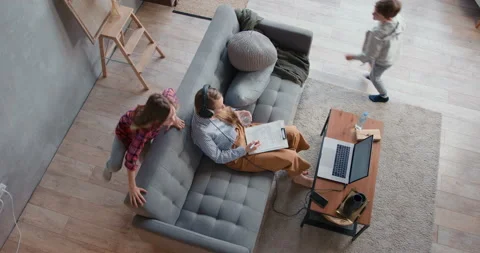 Top view stressed mother trying to work from home online on laptop distracted by Stock Footage 129083324