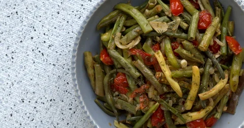 Top view of string beans sauted with tomatoes, onion, garlic and dried thyme. Stock Footage 284563601