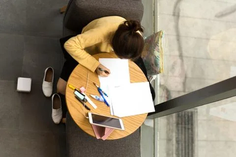 Top view student doing homework in coffee shop with notepad Stock Photos