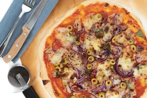 Top view studio shot of freshly baked pizza al tonno on baking paper, isolated Stock Photos
