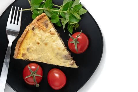 Top view studio shot of a slice of yellow French salty cake, or quiche, with Stock Photos