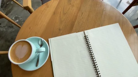 Top view of study and work at the cafe. a cup coffee with an open book on the wo Stock Footage 218765485